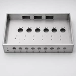 Top view of brushed aluminum amplifier chassis showing tube socket holes and transformer cutouts