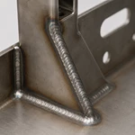 Close-up of continuous MIG weld seam on a welded steel chassis frame corner joint